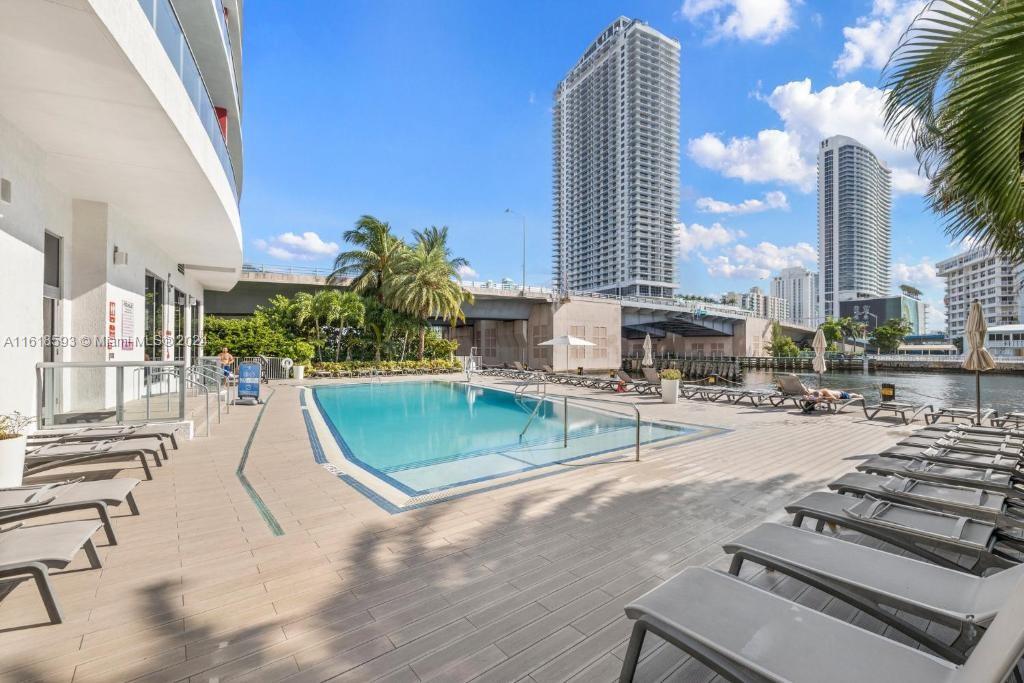 A swimming pool sits on a deck with lounge chairs near a waterfront bridge — 2602 E Hallandale Beach Blvd # R807, Hallandale Beach FL 33009, HALLANDALE BEACH, FL