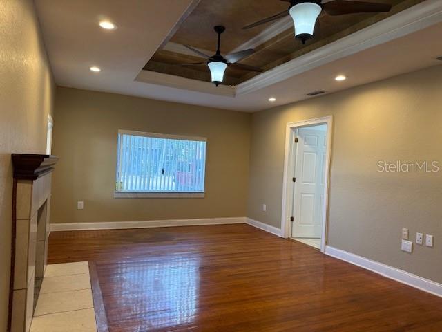 A living room features hardwood floors, a tray ceiling with two fans, and a fireplace — 207 N CHURCH AVENUE UNIT 207, MULBERRY, FL