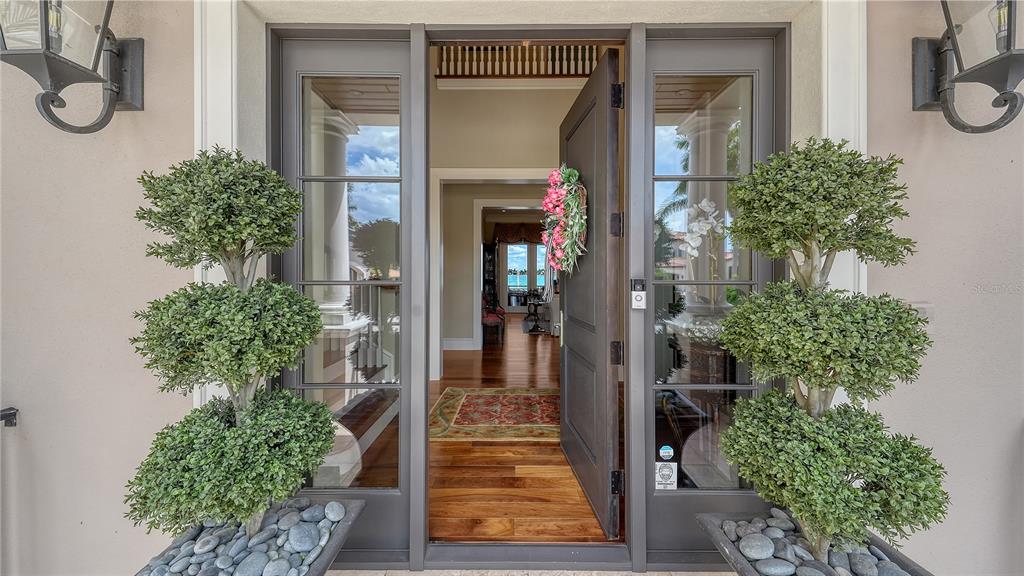 An open front door reveals an entryway with hardwood floors and a view through the home — 667 MOURNING DOVE DRIVE, SARASOTA, FL