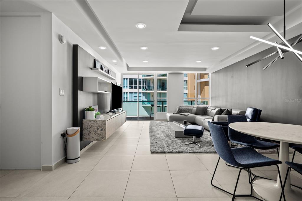 A modern living room features light tile floors, a floating media console, and a sectional sofa — 25 Ave Muñoz Rivera BAHIA PLAZA APT UNIT 616, SAN JUAN, PR