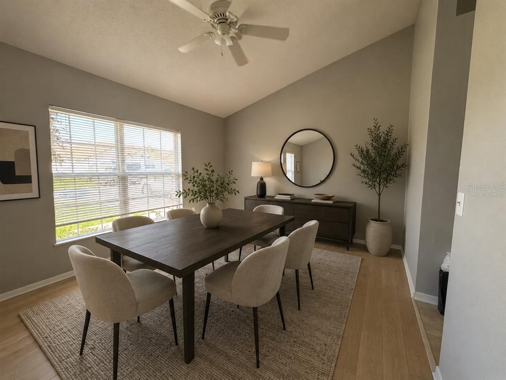 A dining room features a dark wood table, six chairs, and a round wall mirror — 20 ANDORA COURT, KISSIMMEE, FL