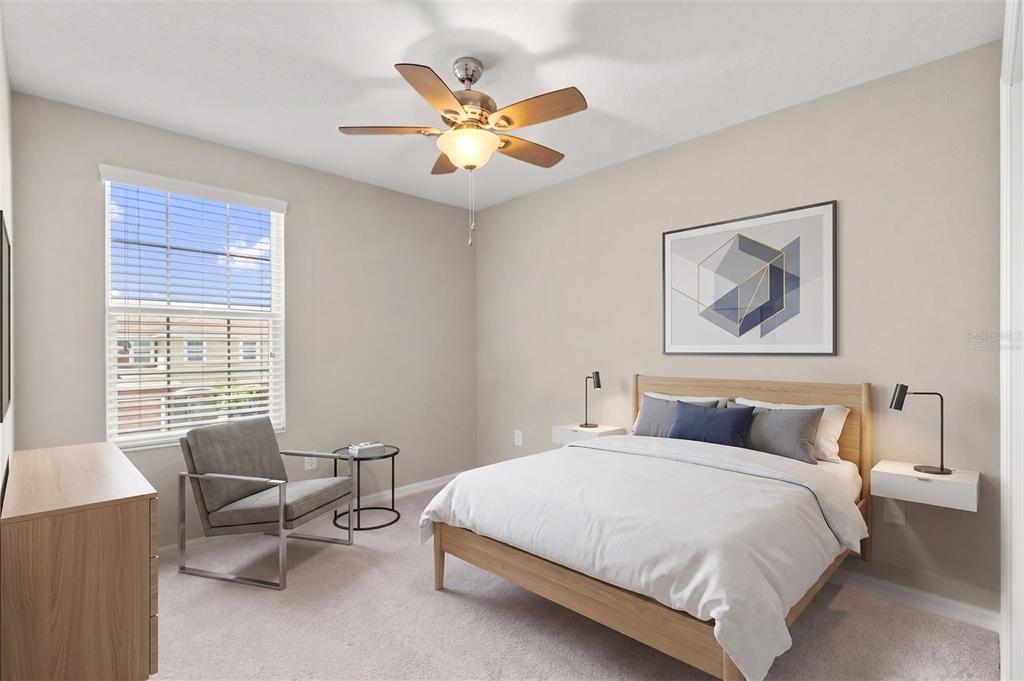 A bedroom features a light wood bed frame, a gray armchair, and a ceiling fan — 7060 WOODCHASE GLEN DRIVE, RIVERVIEW, FL