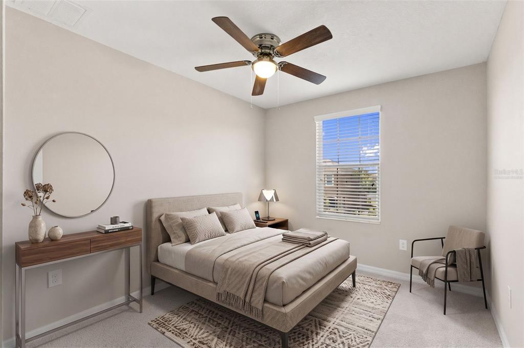 A bedroom features a bed, a ceiling fan, a console table with a mirror, and seating — 7060 WOODCHASE GLEN DRIVE, RIVERVIEW, FL