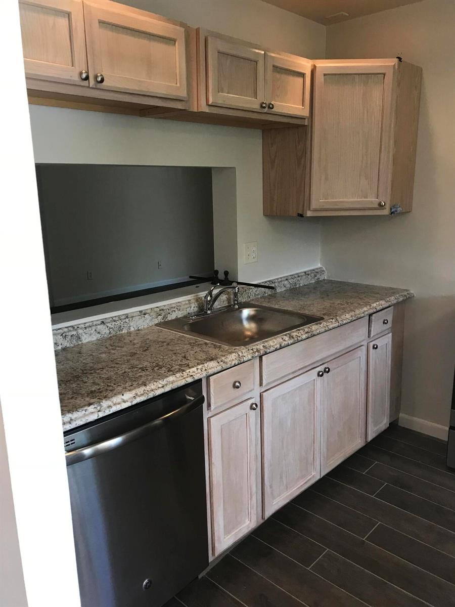A kitchen features light wood cabinets, granite countertops, a stainless steel sink, and dark flooring — 3629 NW 94th Avenue # 5g, Sunrise FL 33351, SUNRISE, FL