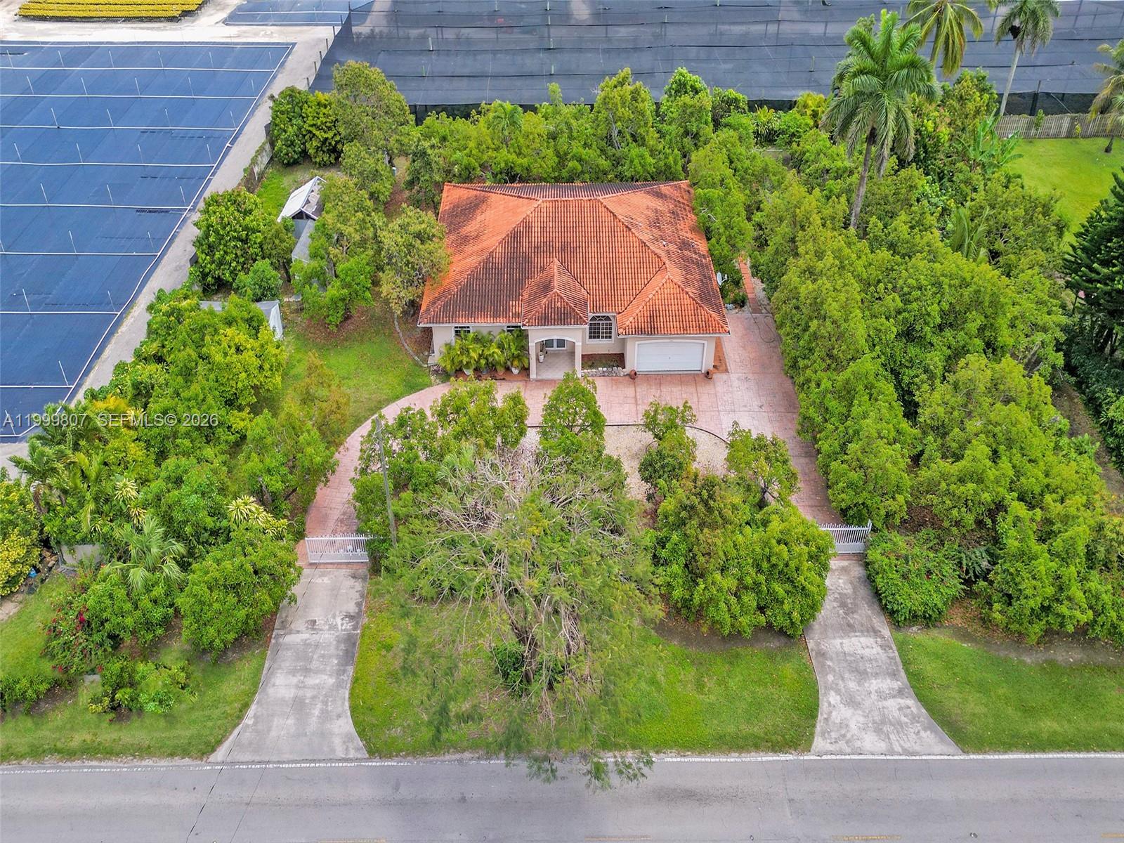 An aerial view shows a house with a red tile roof and two gated driveways — 23001 SW 167th Ave, Miami FL 33170, MIAMI, FL