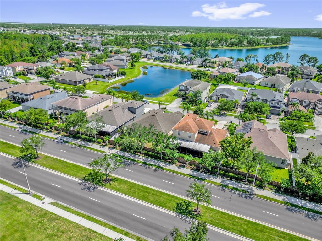 An aerial view shows suburban houses situated near a pond and a large lake — 14749 BRUNSWOOD WAY, ORLANDO, FL