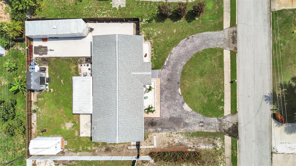 An aerial view shows a house with a gray roof, a circular driveway, and backyard structures — 5931 49TH AVENUE N, ST PETERSBURG, FL