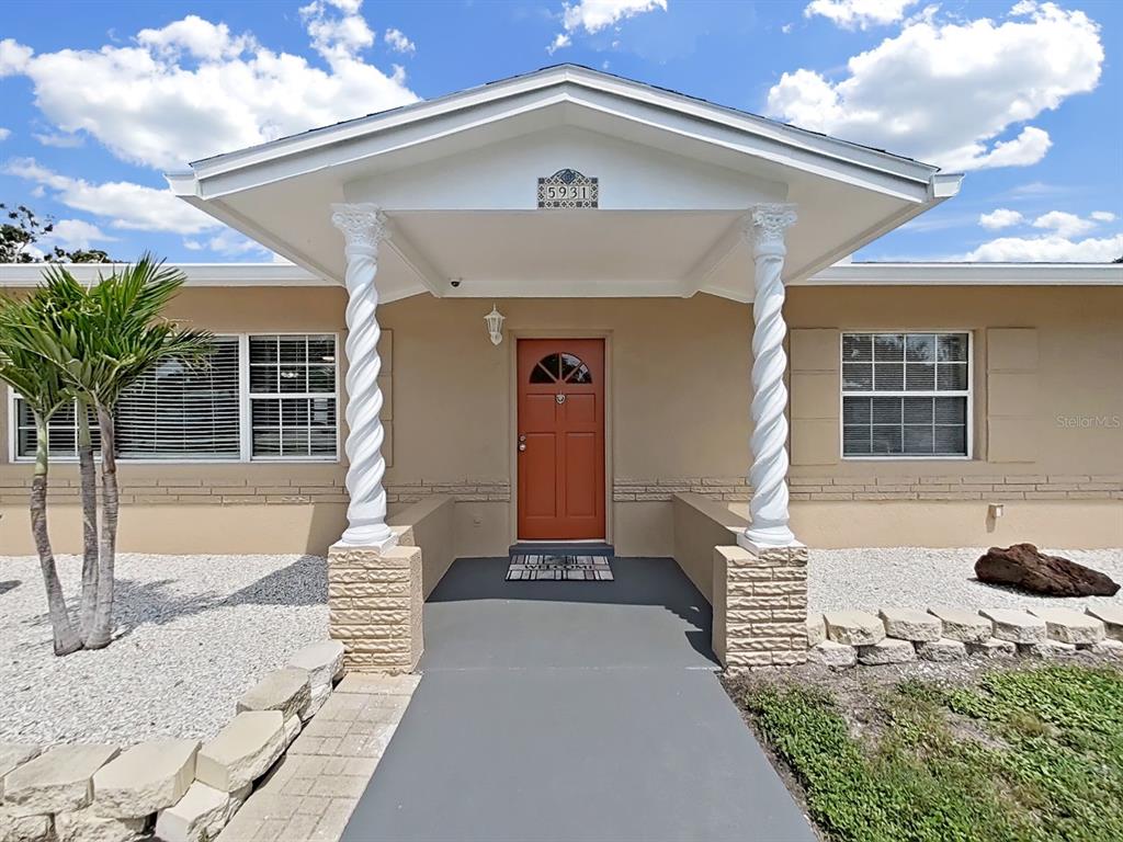 The exterior of a house features a covered entryway with two white spiral columns — 5931 49TH AVENUE N, ST PETERSBURG, FL