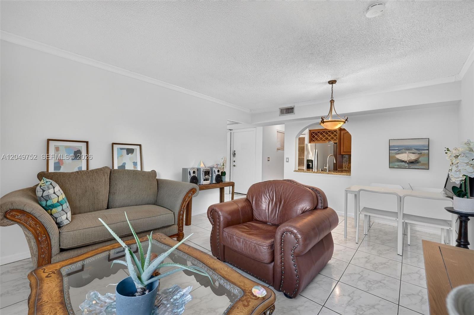 A living room features a brown sofa, a leather armchair, and a dining area — 14929 SW 104th St # 14, Miami FL 33196, MIAMI, FL