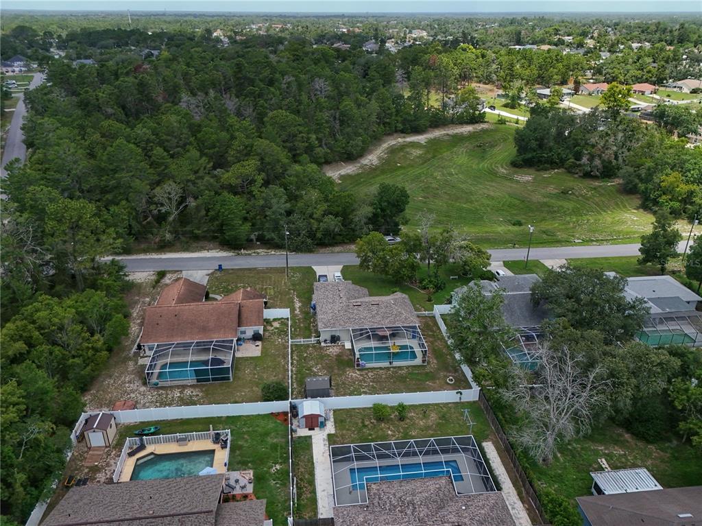 An aerial view of several suburban houses with swimming pools and fenced backyards — 2281 FAYSON LANE, SPRING HILL, FL