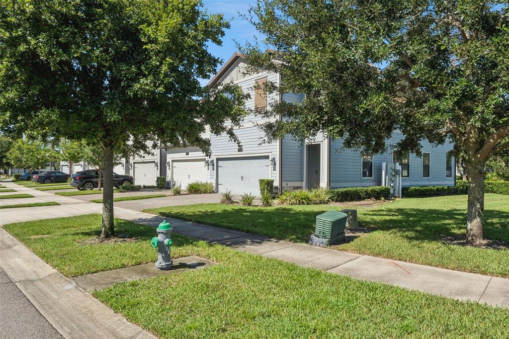 A light blue two-story townhouse with a two-car garage and a front lawn — 11433 WHISTLING PINE WAY, ORLANDO, FL