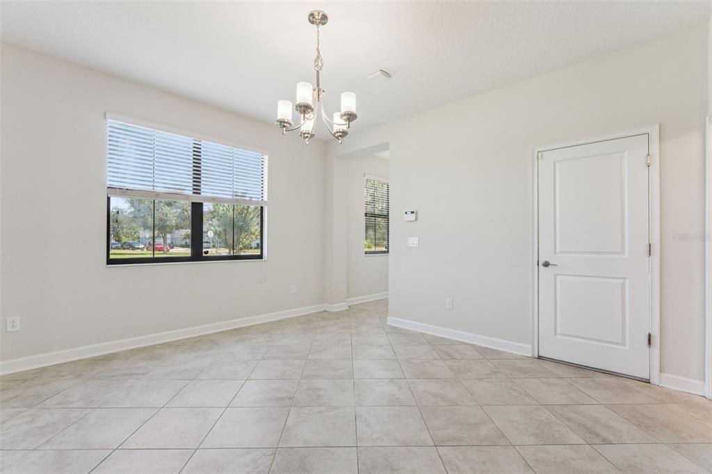 A bright dining room with tile flooring, a chandelier, and a white interior door — 11433 WHISTLING PINE WAY, ORLANDO, FL