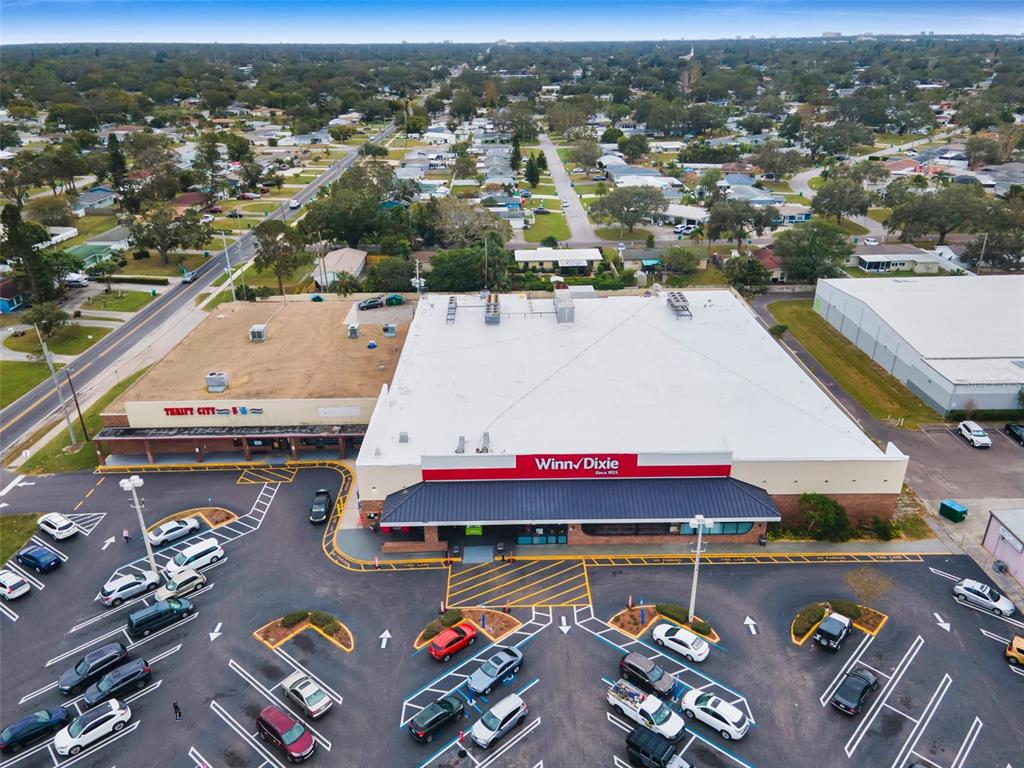 An aerial view shows a Winn-Dixie grocery store and Thrift City in a shopping center parking lot — 5802 54TH AVENUE N, KENNETH CITY, FL