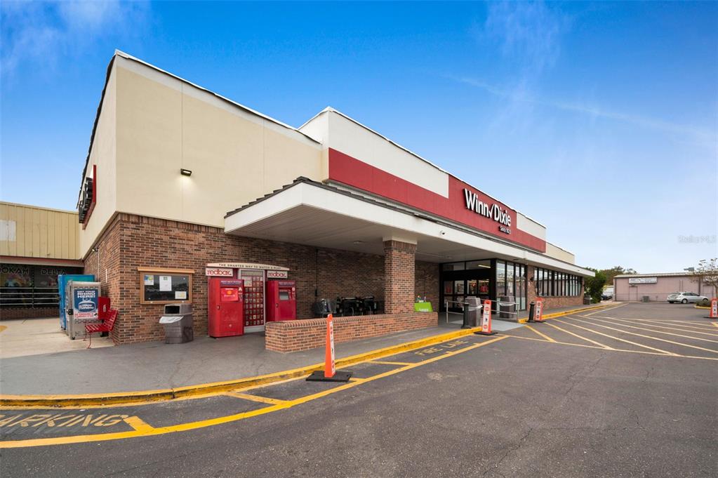 The exterior of a Winn-Dixie grocery store features a brick facade and a covered entrance — 5802 54TH AVENUE N, KENNETH CITY, FL
