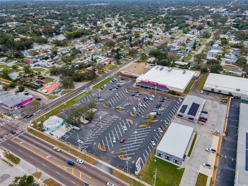 An aerial view shows a Winn-Dixie grocery store with a large parking lot and surrounding neighborhood — 5802 54TH AVENUE N, KENNETH CITY, FL