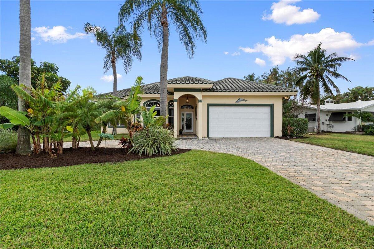 A single-story house with a tiled roof, a white garage door, and a paved driveway — 72 Waterway Road, Jupiter FL 33469, JUPITER, FL