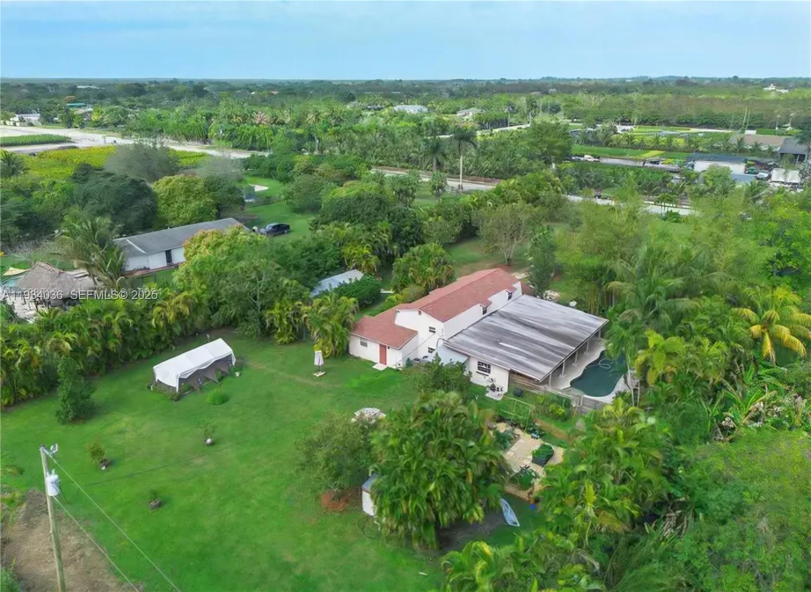 An aerial view shows a house with a red roof, a pool, and a large yard — 19810 SW 200th St, Miami FL 33187, MIAMI, FL