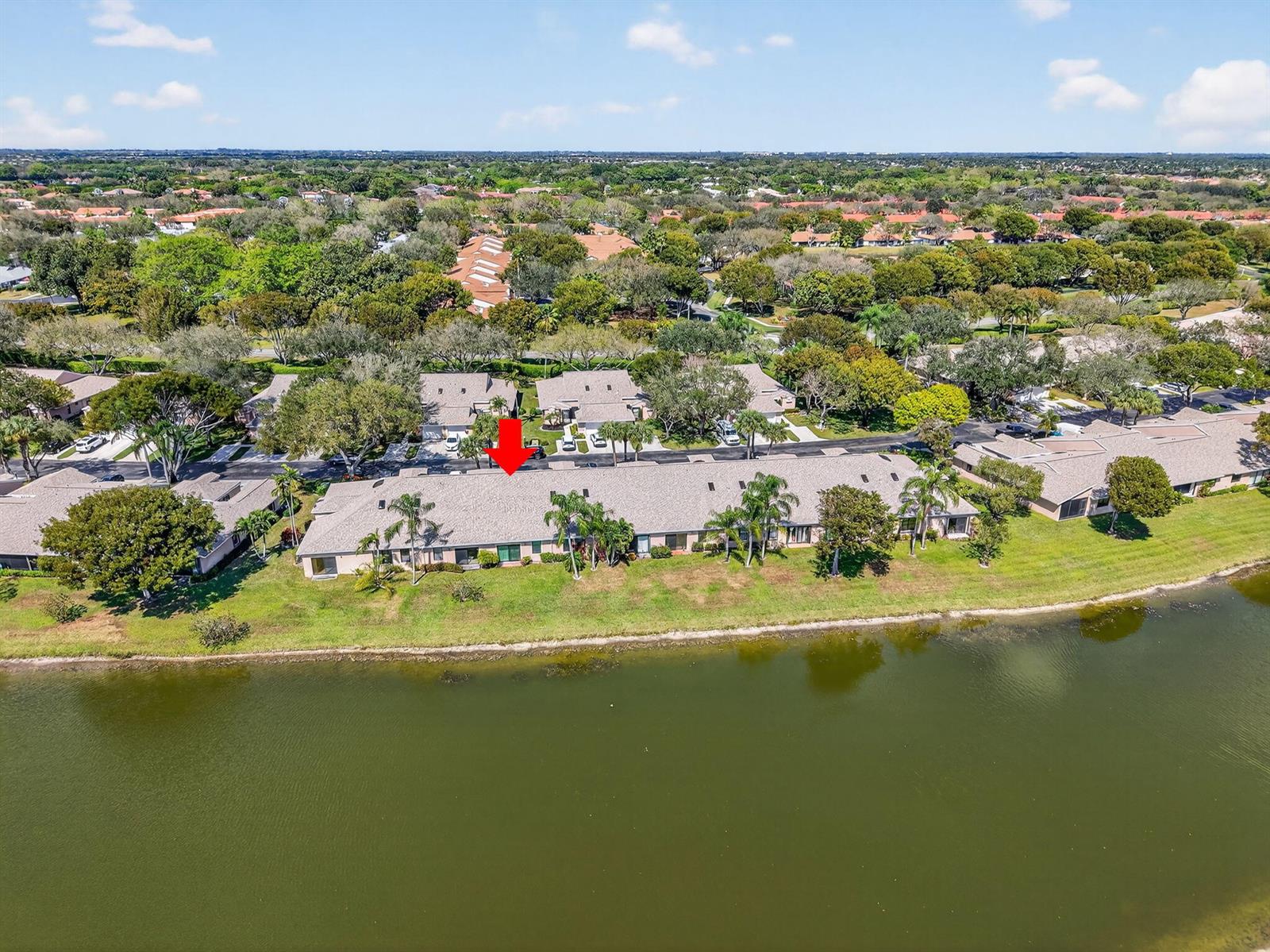 An aerial view shows a residential townhouse complex situated along a lakefront — 8350 Springlake Drive, Boca Raton FL 33496, BOCA RATON, FL