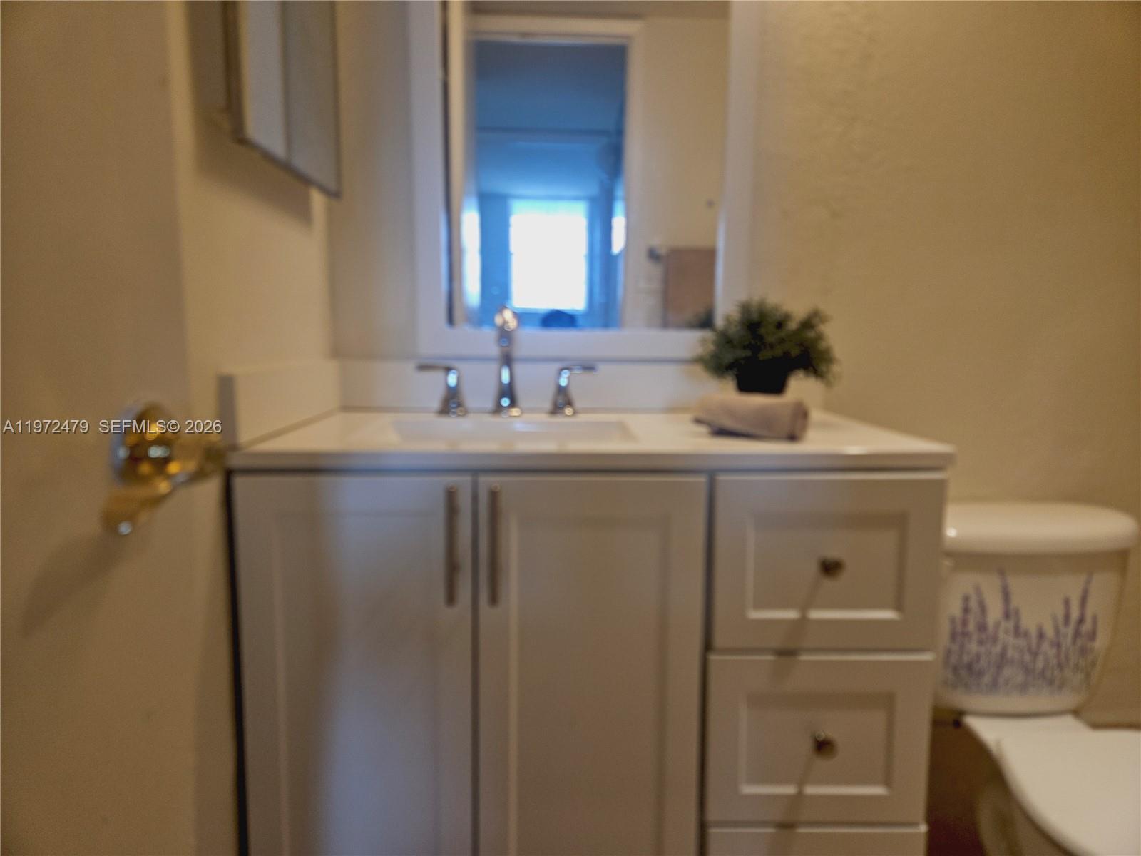 A bathroom features a white vanity, a sink with a chrome faucet, and a toilet — 4550 NW 9th St # 704E, Miami FL 33126, MIAMI, FL