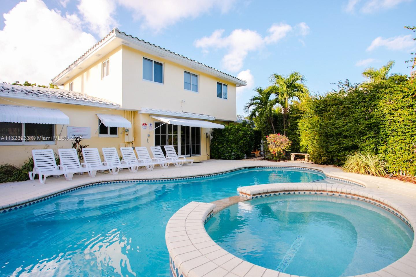 A two-story yellow house features a swimming pool and attached hot tub in the backyard — 809 S 17th Ave, Hollywood FL 33020, HOLLYWOOD, FL