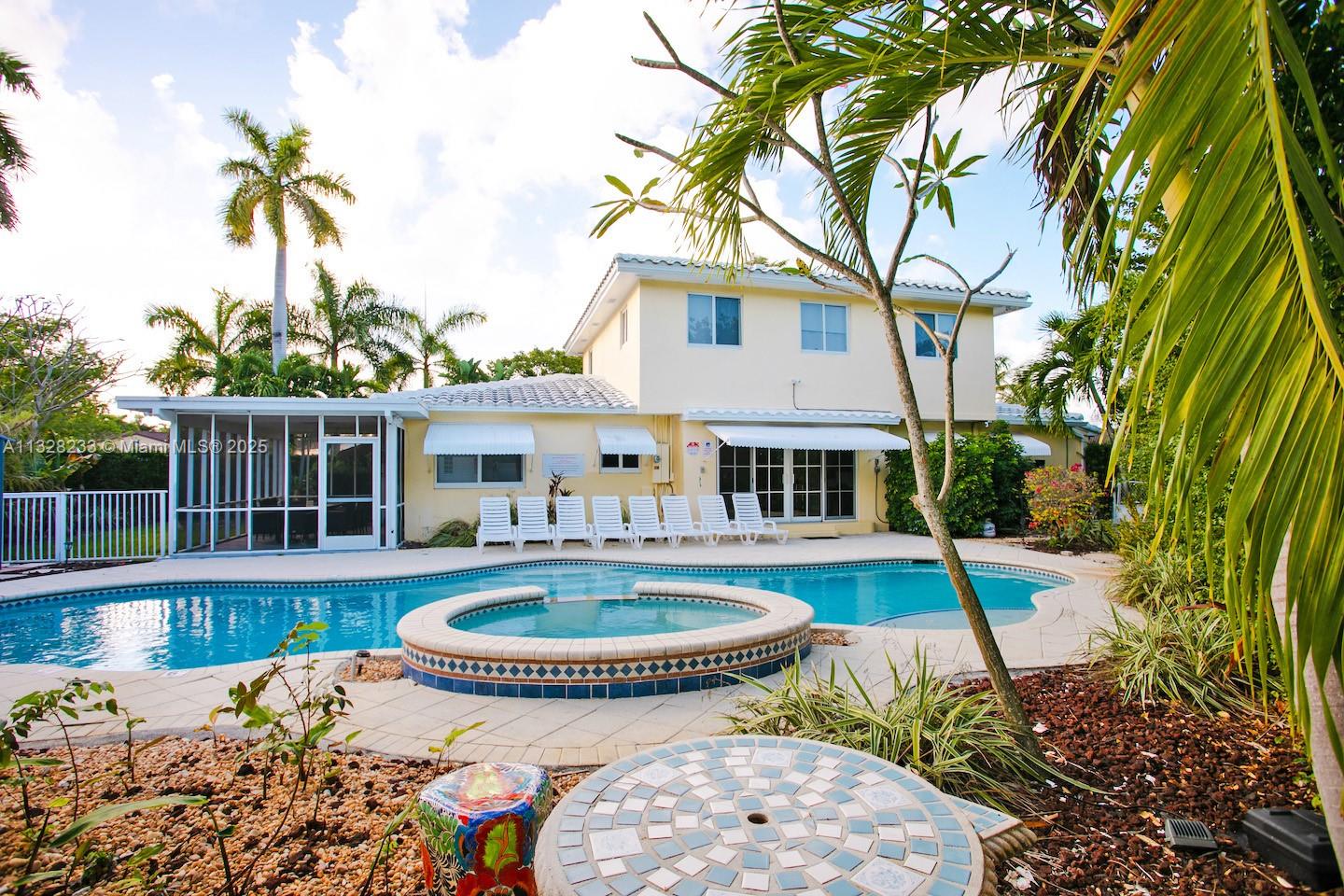 A two-story yellow house features a swimming pool, a hot tub, and a patio area — 809 S 17th Ave, Hollywood FL 33020, HOLLYWOOD, FL