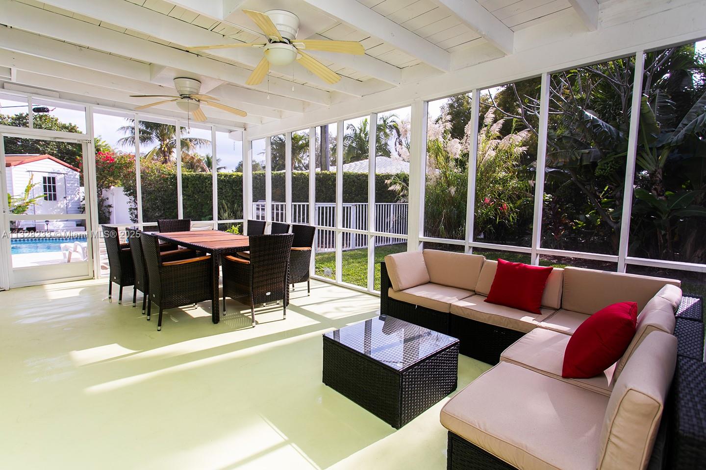 A screened-in patio features a dining set, sectional sofa, and ceiling fans overlooking a pool — 809 S 17th Ave, Hollywood FL 33020, HOLLYWOOD, FL