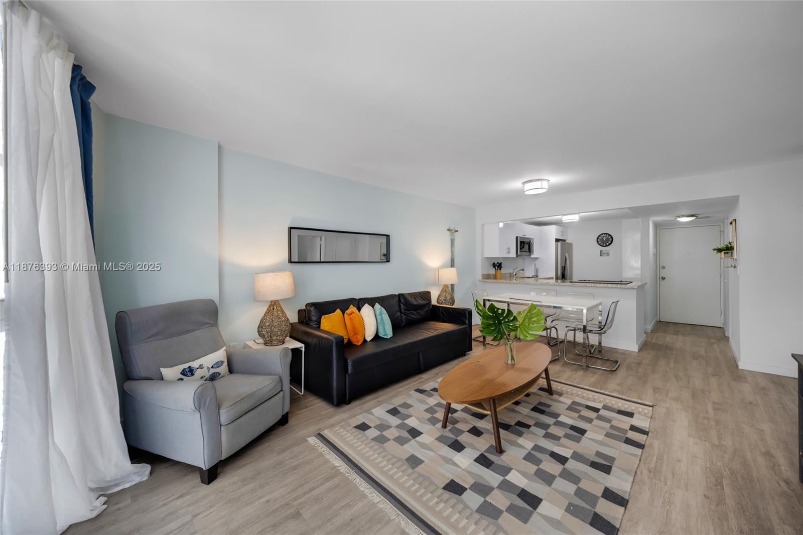 A living room features a black sofa, gray armchair, coffee table, and an open kitchen — 1228 West Ave # 312, Miami Beach FL 33139, MIAMI BEACH, FL