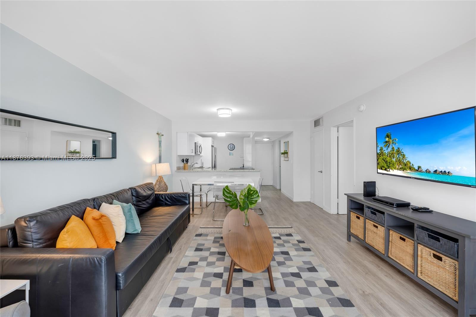 A living room features a black leather sofa, a wooden coffee table, and a television — 1228 West Ave # 312, Miami Beach FL 33139, MIAMI BEACH, FL