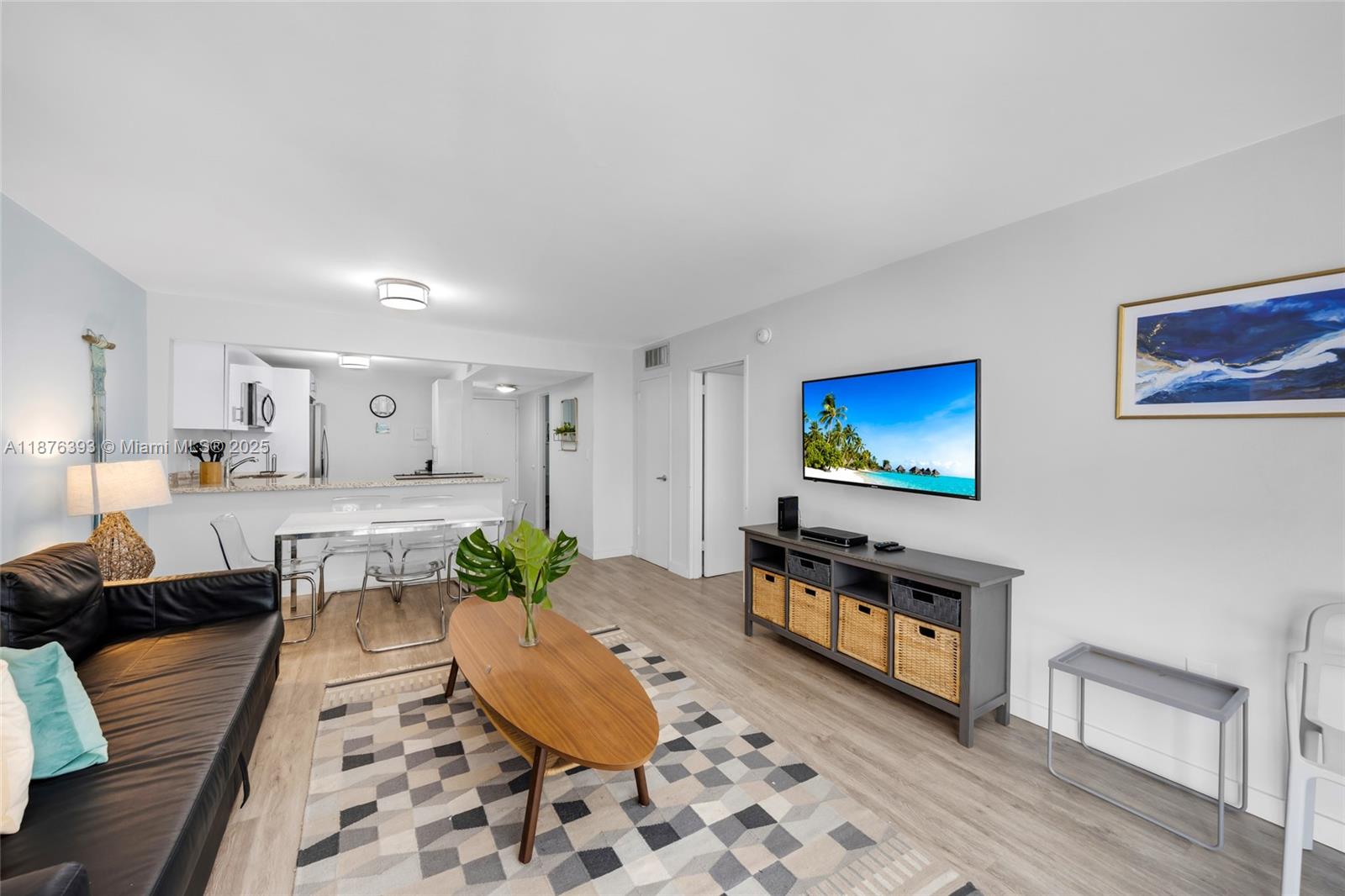 A living room features a black leather sofa, a wooden coffee table, and a television — 1228 West Ave # 312, Miami Beach FL 33139, MIAMI BEACH, FL