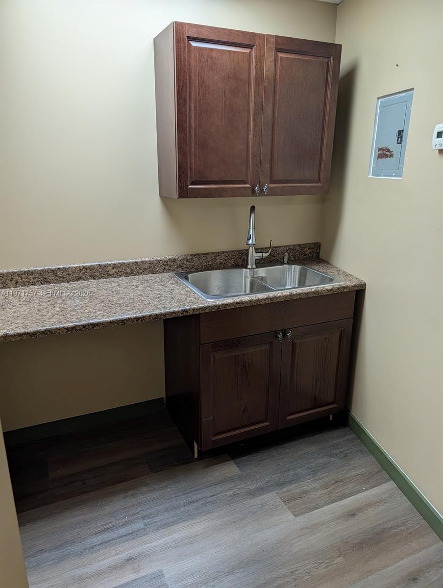A small kitchenette features dark wood cabinets, a granite countertop, and a stainless steel sink — 801 S Dixie Hwy W, Pompano Beach FL 33060, POMPANO BEACH, FL