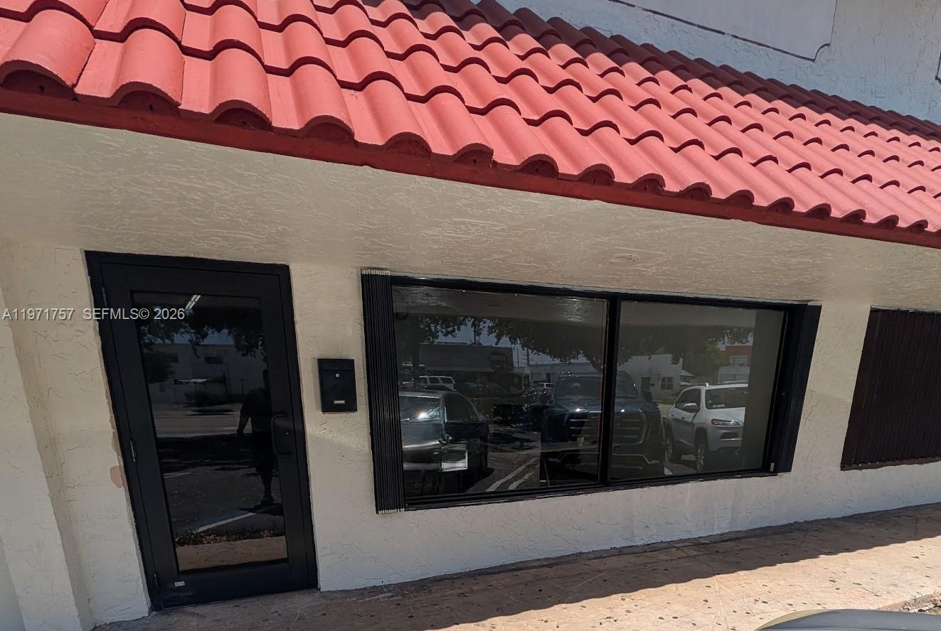 The exterior of a commercial building features a red tile roof and a glass door — 801 S Dixie Hwy W, Pompano Beach FL 33060, POMPANO BEACH, FL