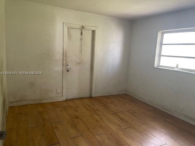 An empty room features light wood-look tile flooring, white walls, and a single window — 758 SW 3rd Pl, Dania Beach FL 33004, DANIA BEACH, FL