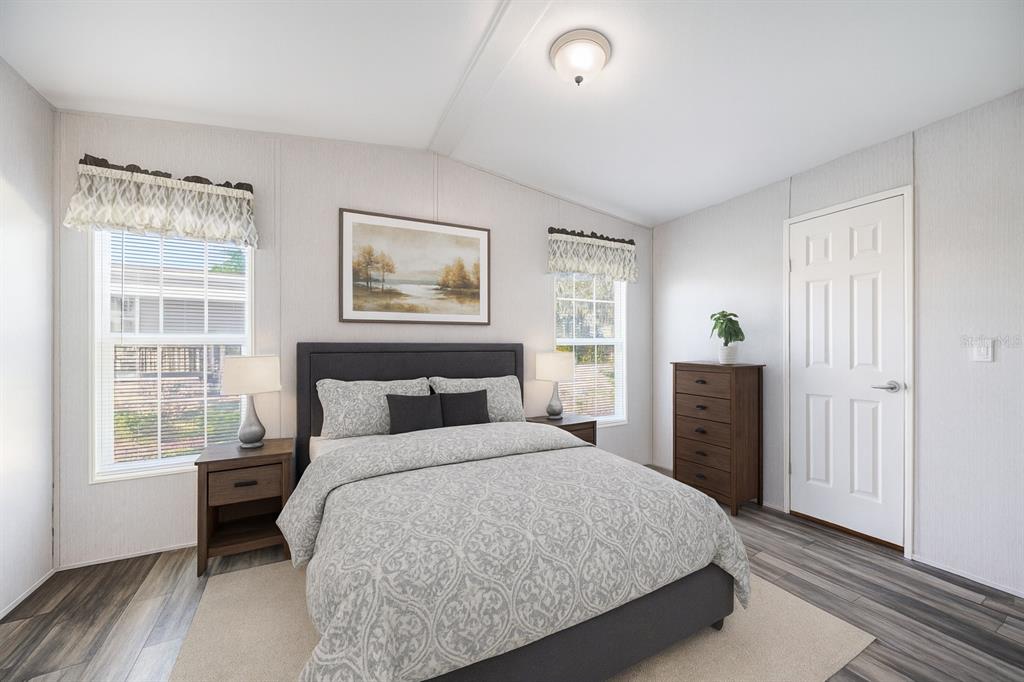 A bedroom features a queen bed, two nightstands, a dresser, and two windows with valances — 1 BEAVERKILL DRIVE, LAKE WALES, FL