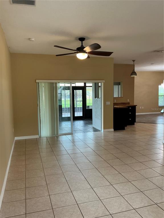 A living area with tile floors, a ceiling fan, and sliding glass doors to a patio — 3630 NORTHWOODS DRIVE, KISSIMMEE, FL