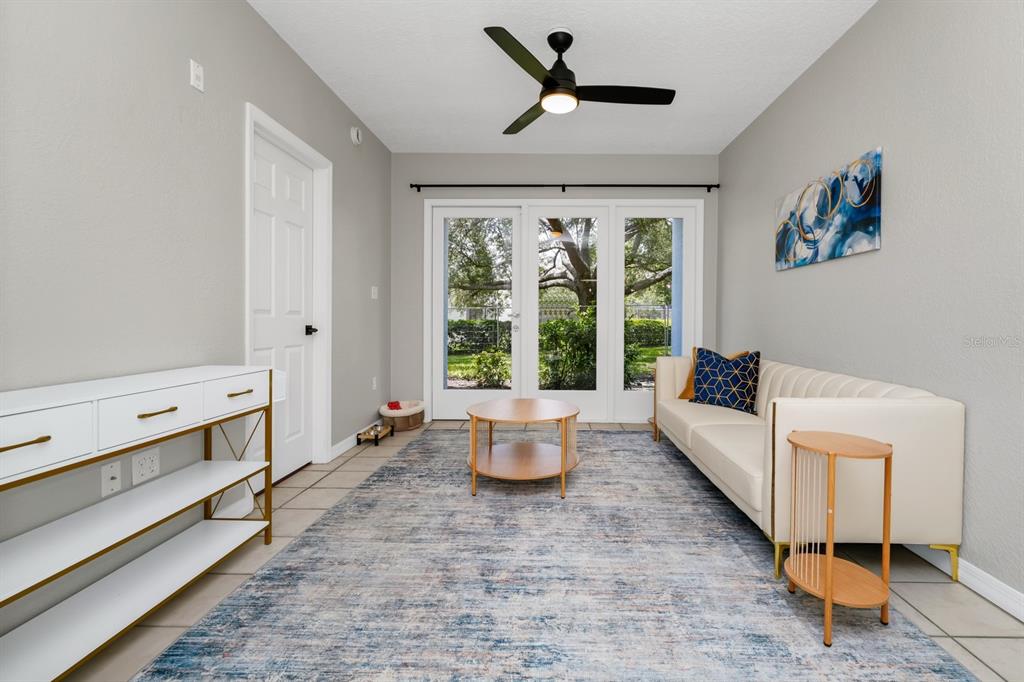 A living room with a white sofa, a blue area rug, and glass patio doors — 2954 SADINA STREET UNIT Tower 3, KISSIMMEE, FL
