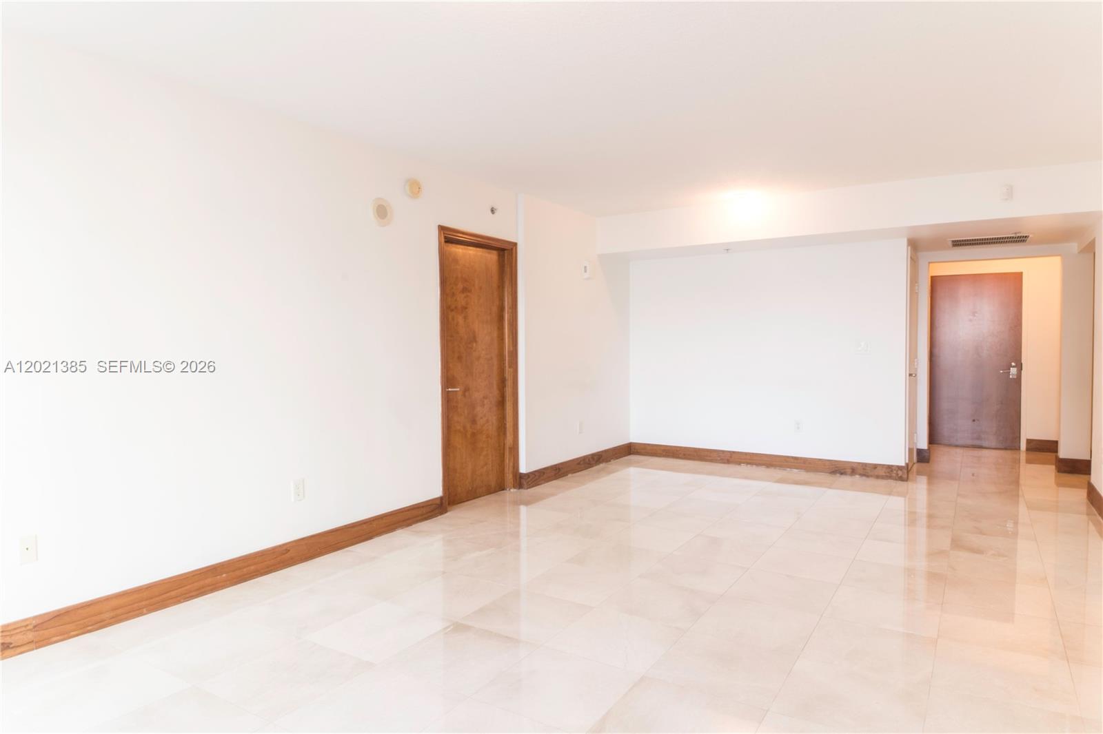 An empty room features white walls, light-colored tile flooring, and wood baseboards — 31 SE 5th St # 1208, Miami FL 33131, MIAMI, FL