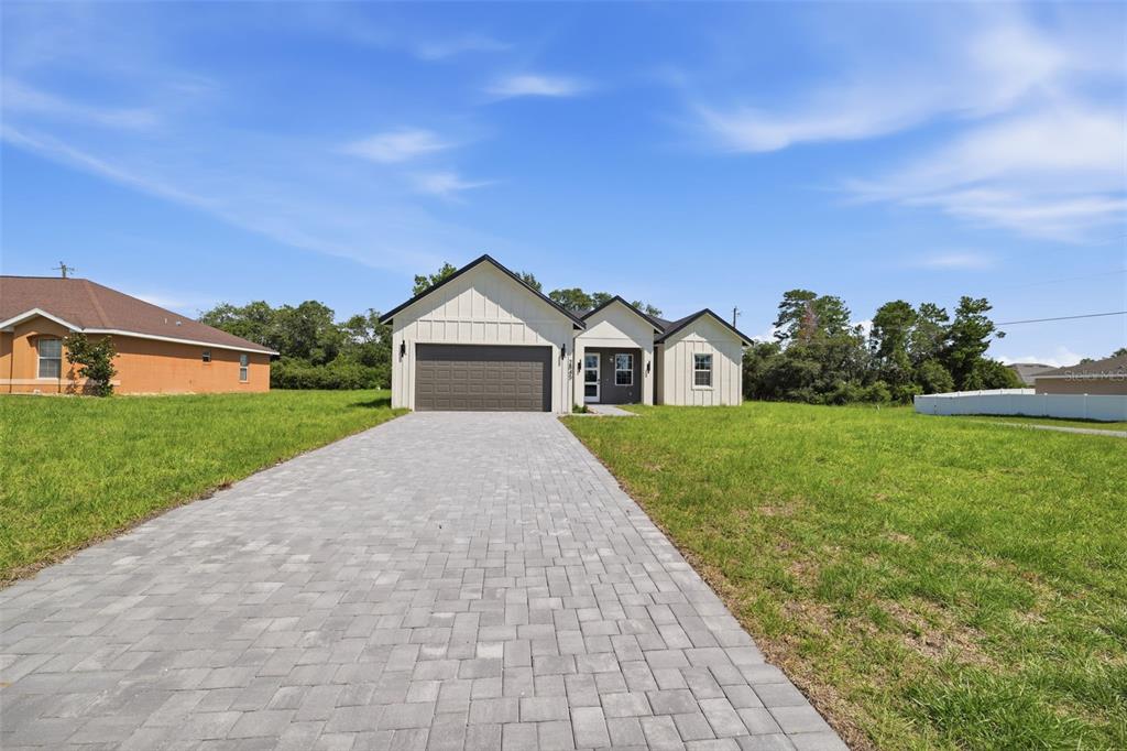 A modern single-story house with a paved driveway and a two-car garage — 2845 SW 172ND LANE ROAD, OCALA, FL