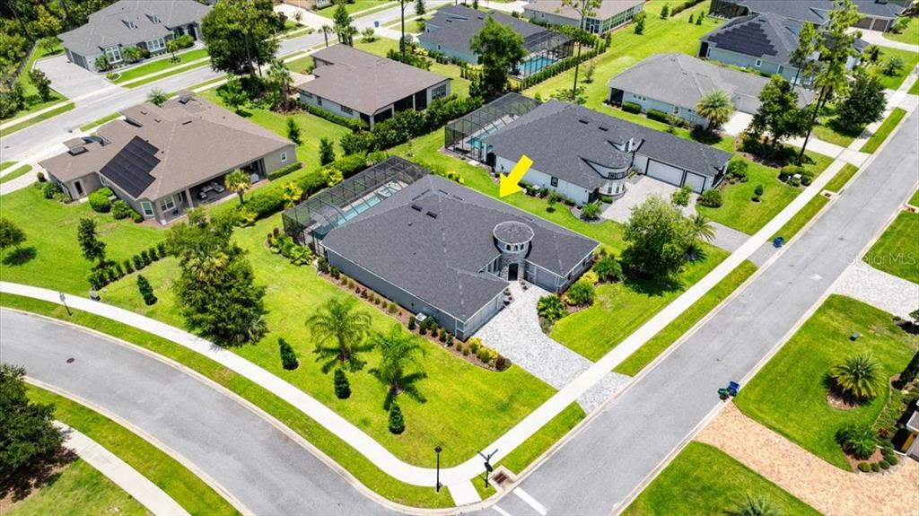 An aerial view shows a suburban house with a dark roof and a pool enclosure — 2426 WILD TURKEY CREEK LN, PORT ORANGE, FL