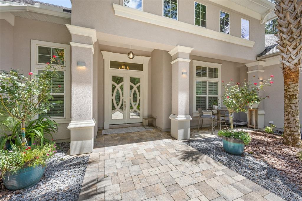 The exterior of a house features a paved walkway leading to a double front door — 11372 SW 30TH AVENUE, GAINESVILLE, FL