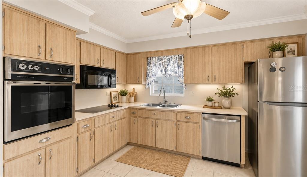 A kitchen with light wood cabinets, stainless steel appliances, and a window above the sink — 6643 KELSEY LANE UNIT 4B, NEW PORT RICHEY, FL