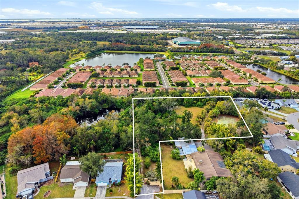An aerial view shows a residential property with a house and large wooded lot — 7808 34TH COURT E, SARASOTA, FL