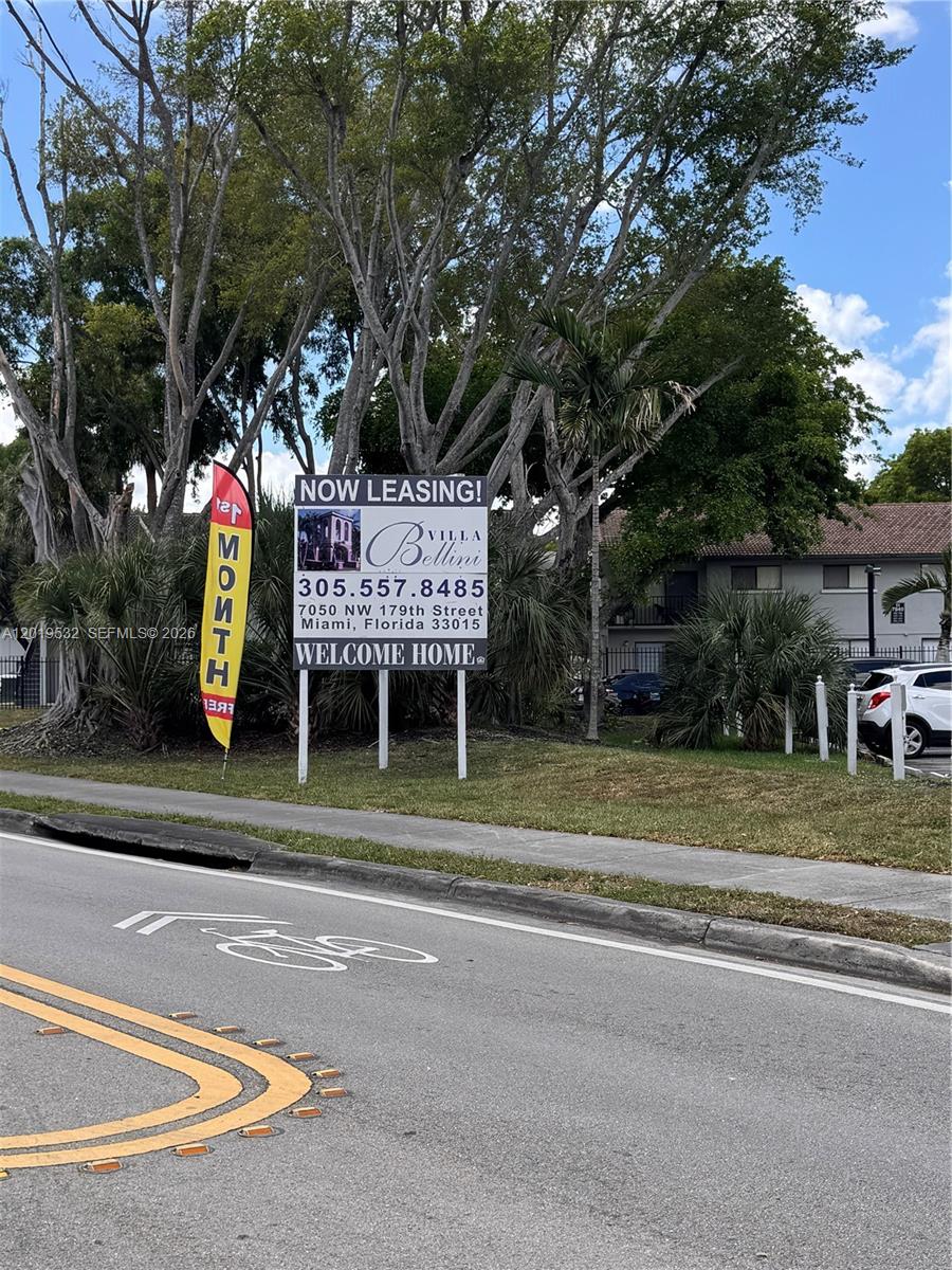 A leasing sign for Villa Bellini stands on a grassy lawn beside a road — 7115 NW 179th St # 207, Hialeah FL 33015, HIALEAH, FL