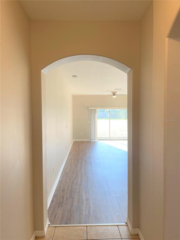 An arched doorway leads from a tiled entryway into a living area with wood-look flooring — 4011 WINDING VINE DRIVE, LAKELAND, FL