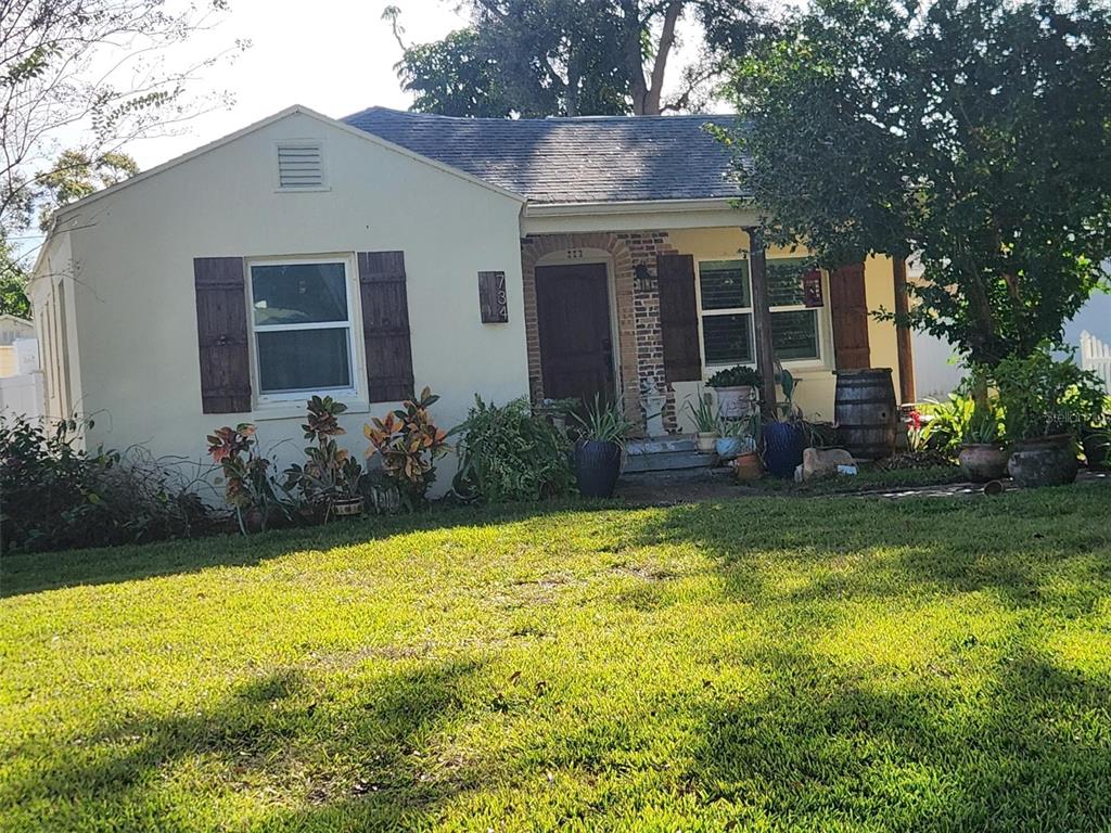 A single-story house with a light-colored exterior, brown shutters, and a front porch — 734 37TH AVENUE N, ST PETERSBURG, FL