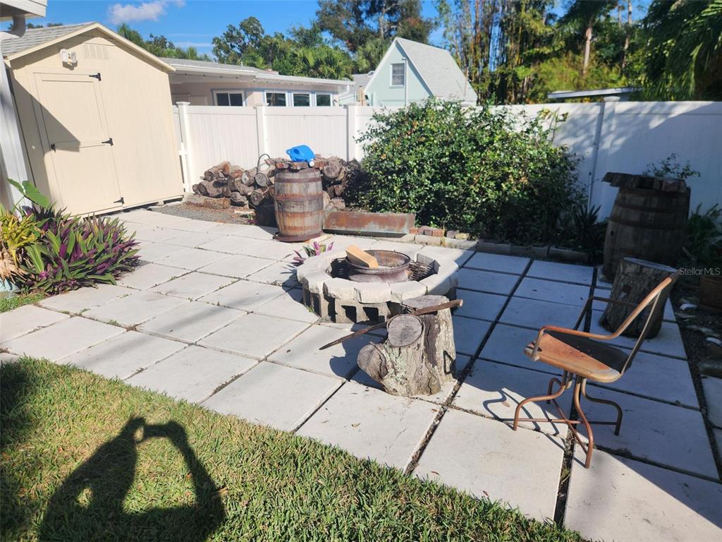 A backyard patio features a stone fire pit, a storage shed, and a wooden barrel — 734 37TH AVENUE N, ST PETERSBURG, FL