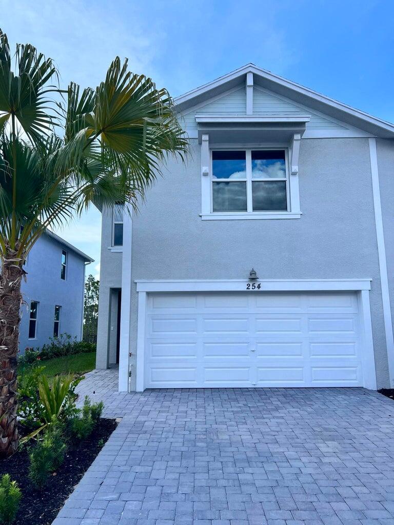 A two-story house with a light gray stucco exterior and a white single-car garage — 254 Osprey Preserve Boulevard, Jensen Beach FL 34957, JENSEN BEACH, FL