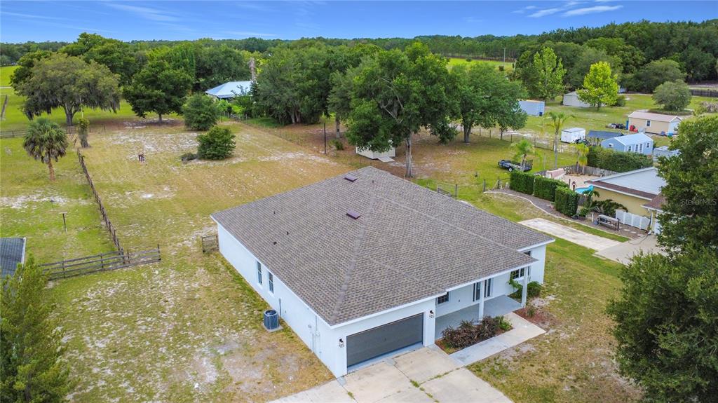 An aerial view shows a single-story house with a hip roof and an attached garage — 28549 SHIRLEY SHORES ROAD, TAVARES, FL