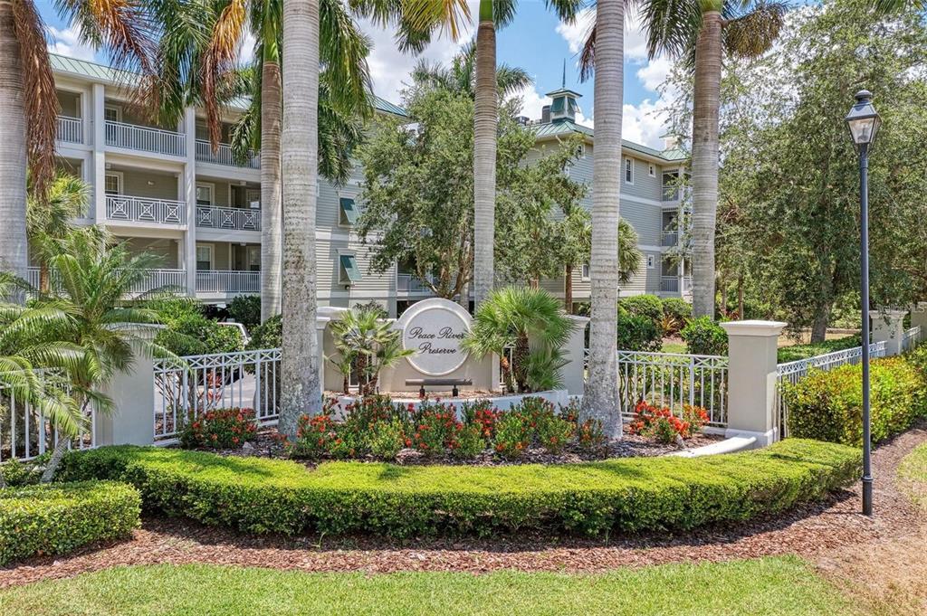 The exterior of a multi-story apartment building features a sign for Peace River Preserve — 5116 MELBOURNE STREET UNIT B-204, PORT CHARLOTTE, FL