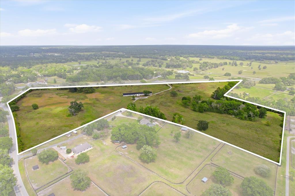 An aerial view shows a large, fenced plot of land with a house and trees — 5465 NW 110TH AVENUE, OCALA, FL