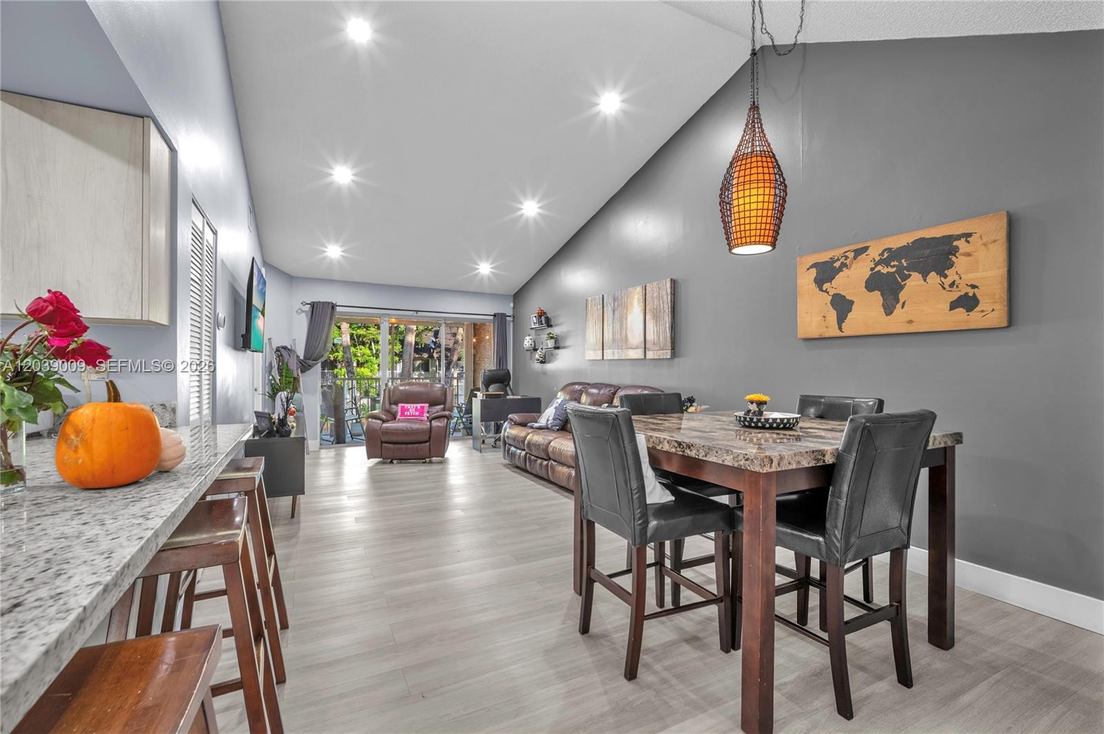 A living and dining area features vaulted ceilings, gray walls, and wood-look flooring — 9507 SW 140th Ct # 9507, Miami FL 33186, MIAMI, FL